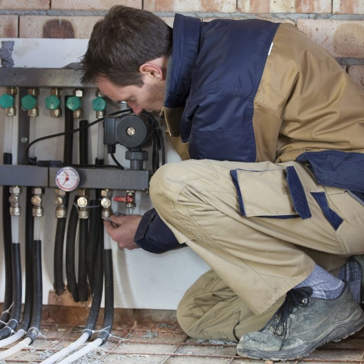 Young man is installing the heating system Underfloor Heating REPAIR & servicing